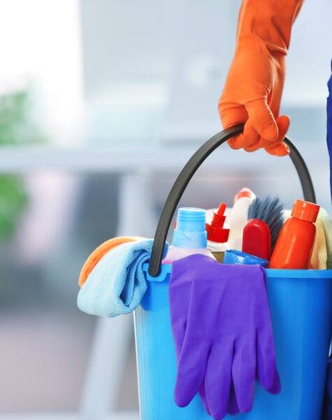 holding cleaning products and tools on bucket, close up