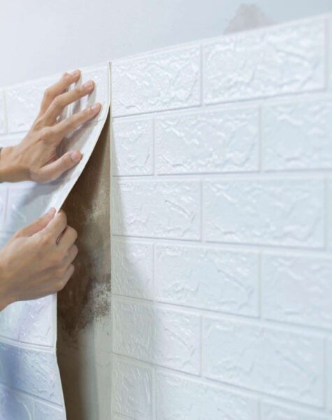 worker-hands-sticking-wallpaper-on-wall